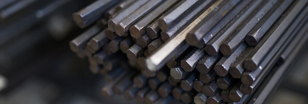 Bright steel bar bundles stored in industrial warehouse